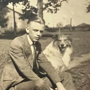Headshot of a young Fred J. Helmen with his dog