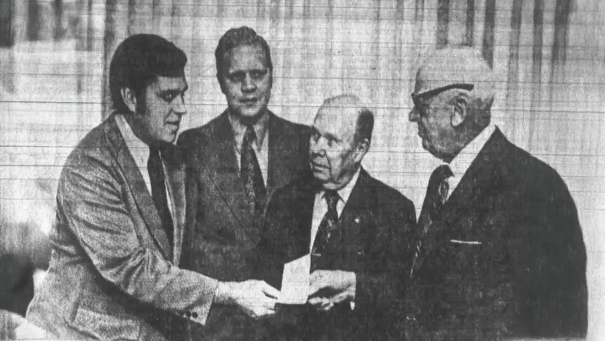 Frederick J. Helmen, acting as President of South Bend's Redevelopment Commission, accepts a check from South Bend Mayor Jerry J. Miller.